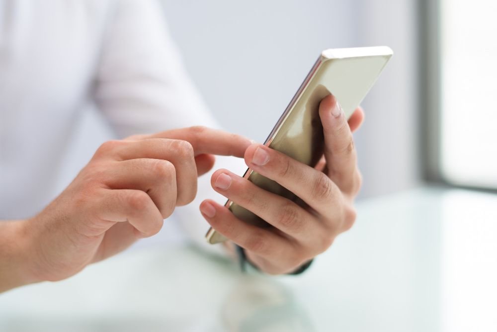 Ljudske ruke drže mobitel i prolaze kroz web stranicu s dobrom responzivnosti za mobitel