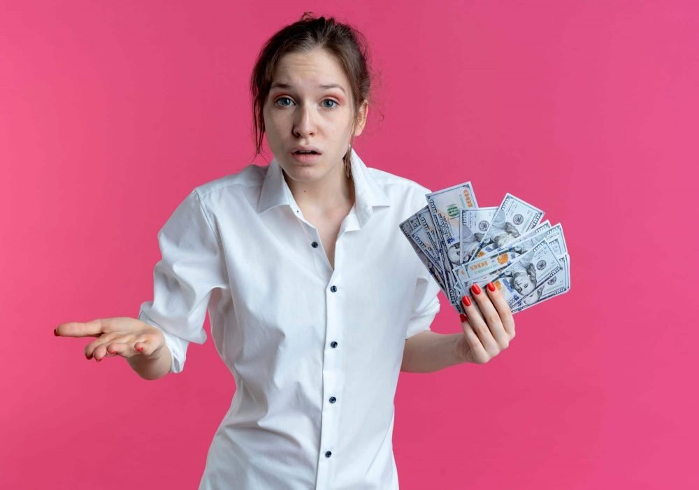 Žena drži novčanice i dvoumi se koji Shopify ili Woocommerce plan kupiti