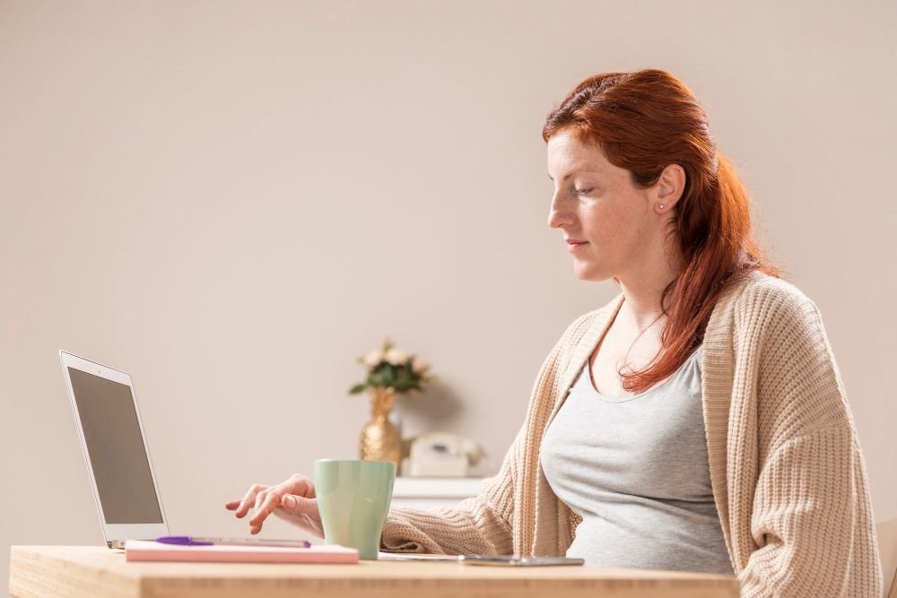 Žena za radnim stolom tipka po laptopu i traži posao od kuće
