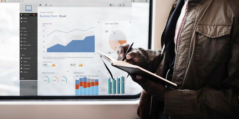 muškarac piše u bilježnicu u pozadini statistika i grafovi